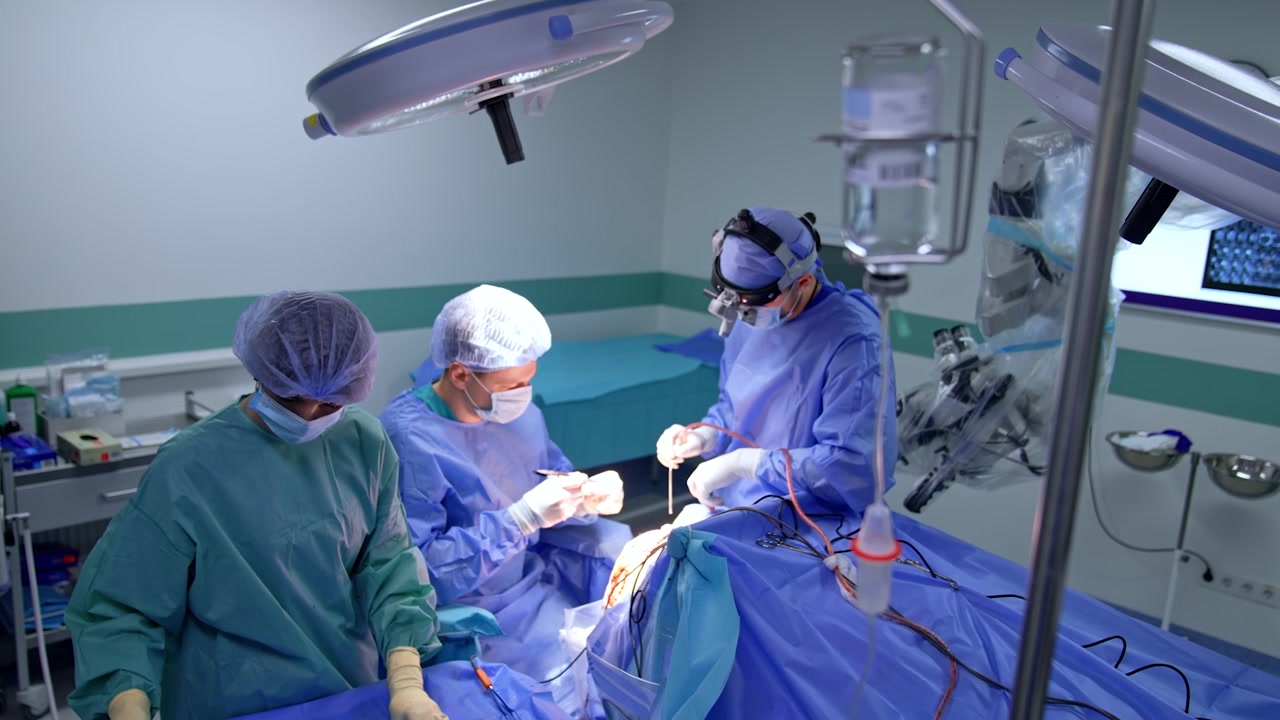Kaukasiske kirurger udfører hjernekirurgi. Operationssygeplejerske forbereder instrumenter og materialer til neurokirurgerne. Højt vinkelperspektiv.