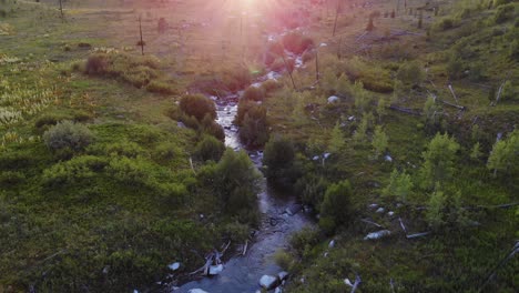 Toma-Aérea-Baja-Sobre-El-Curso-De-Un-Río-En-El-Parque-Grand-Teton-Con-Rayos-De-Sol-En-La-Parte-Superior-De-La-Toma