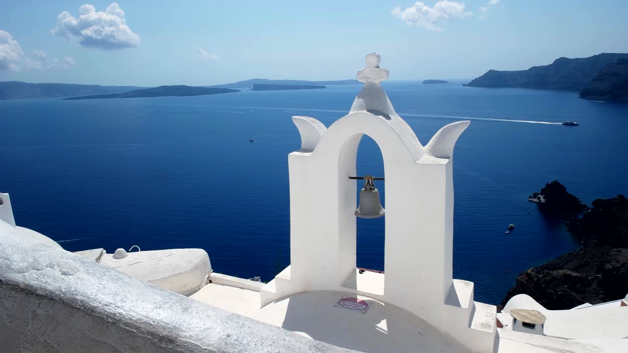 arco de campanas de la iglesia blanqueado y caldera en oia, santorini
