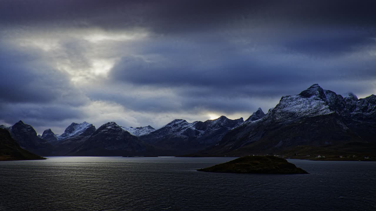 Cold wind blows in the Norwegian fjord surrounded by snow-covered mountains