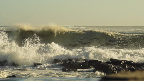 Olas-Del-Mar-Agitadas-Rompiendo-En-La-Costa-Rocosa-Creando-Enormes-Salpicaduras-Y-Espuma---Toma-Estática-Media