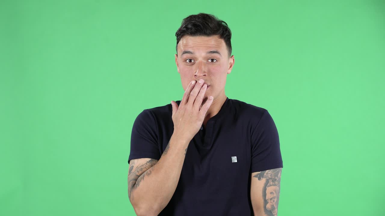 retrato de un joven guapo que mira derecho está diciendo oops y confundido. pantalla verde