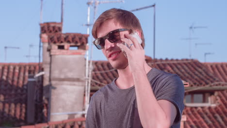 man talking on phone on rooftop