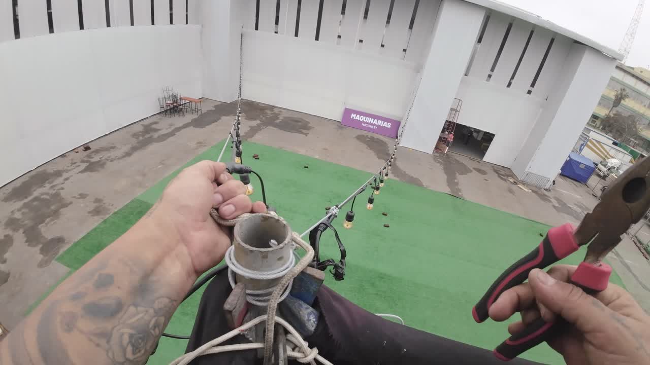 Worker's Hands Using Pliers to Secure Ropes During Event Setup
