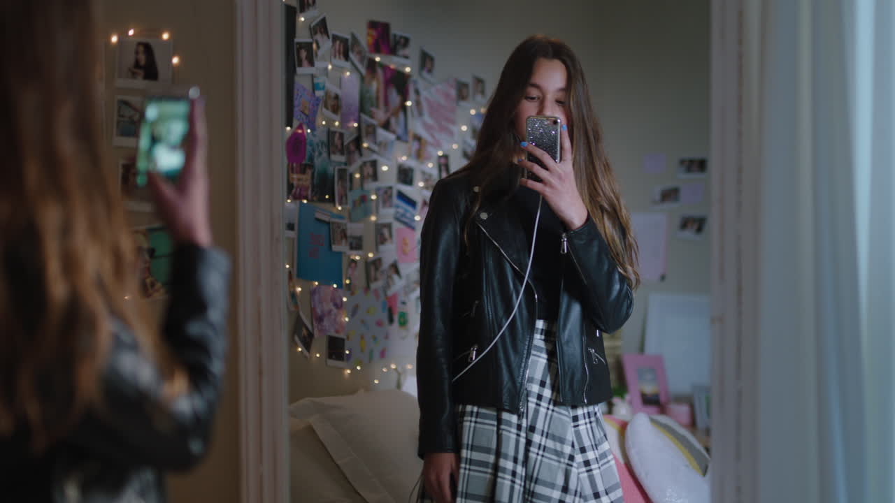 아름다운 십대 소녀가 스마트폰을 사용하여 셀카 사진을 찍고 거울에 포즈를 취하고 소셜 미디어에서 세련된 패션을 공유하고 집에서 주말을 즐기고 십대 자아 이미지