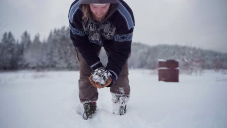 The-Man-is-Clutching-Rocks-Coated-with-Snow-Dust,-Intended-For-Use-in-the-DIY-Hot-Tub---Close-Up