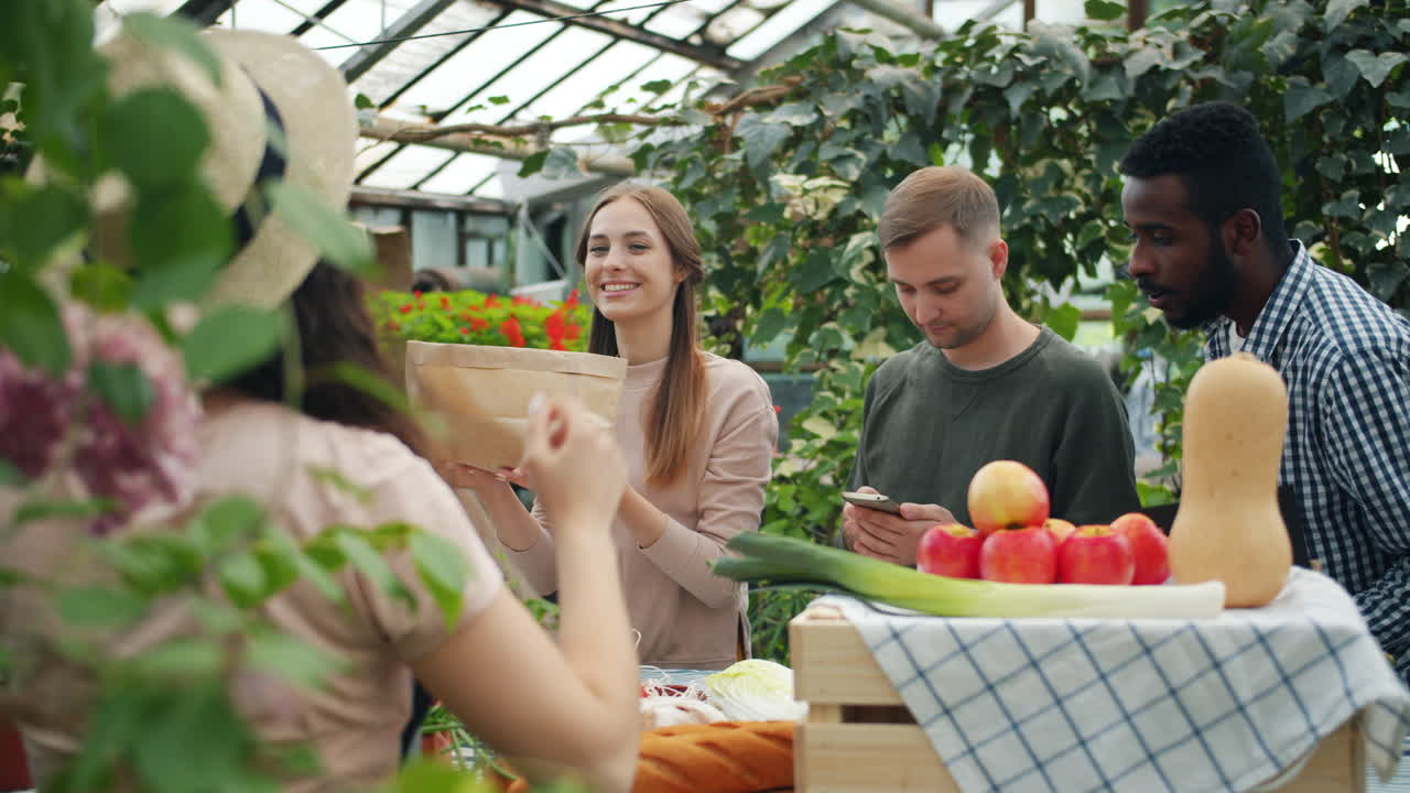 Friends Shopping for Fresh Produce at a Greenhouse Market