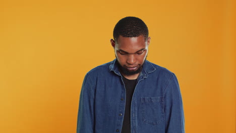 Portrait-of-confident-person-smiling-on-camera-against-orange-background