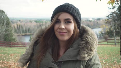 Front-view-of-adult-girl-drinking-hot-beverage-in-cold-windy-autumn-day