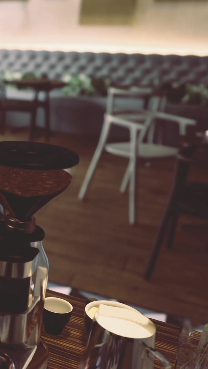 Processo de moagem de café em uma cafeteria com cadeiras e mesas vazias.