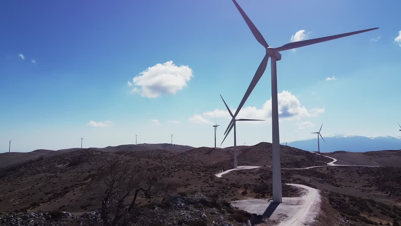 fotografía aérea de turbinas eólicas giratorias en colinas durante un día soleado con cielo azul