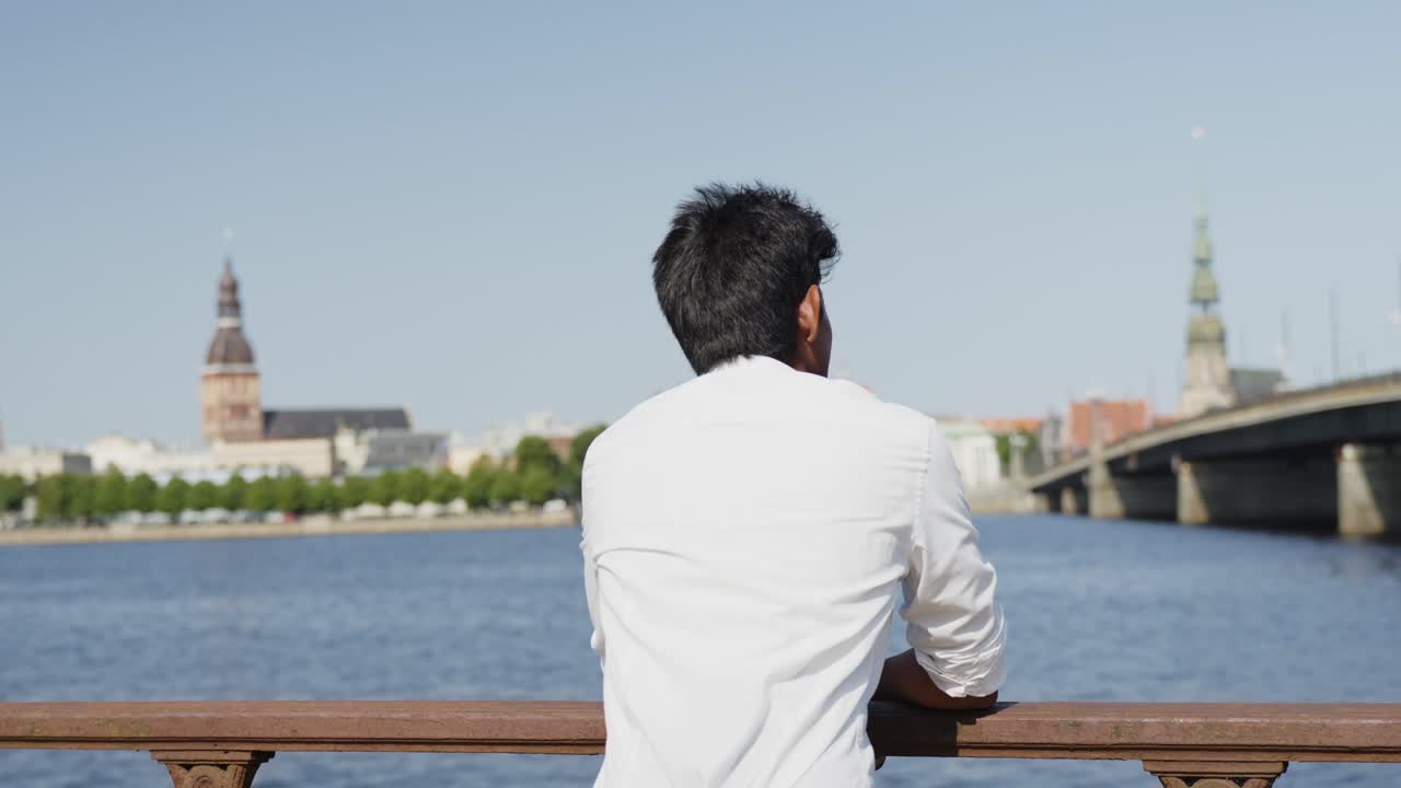 젊은 잘생긴 인도 소년 유럽 도시에서 강을 보고 편안