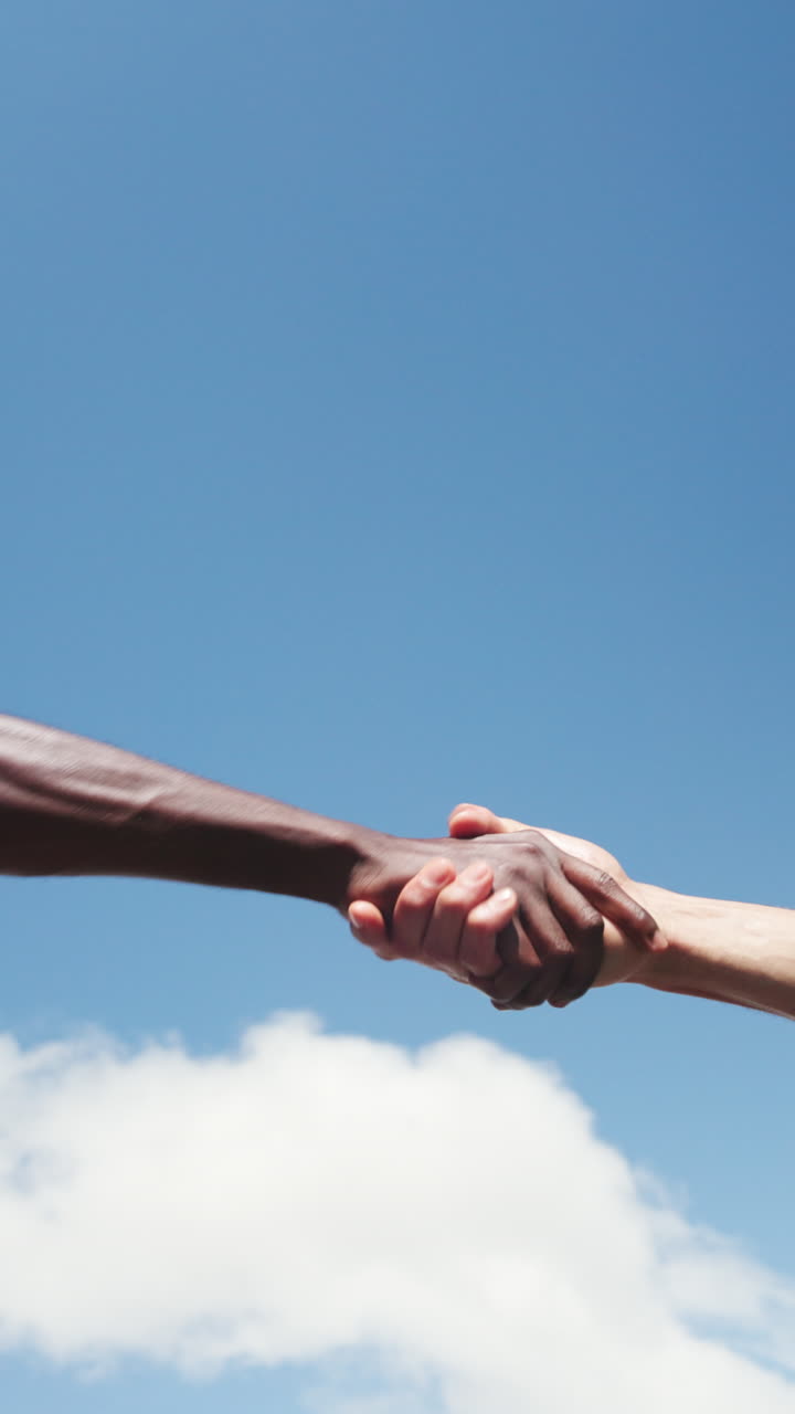 Two Hands Fist Bumping and Shaking Against Blue Sky