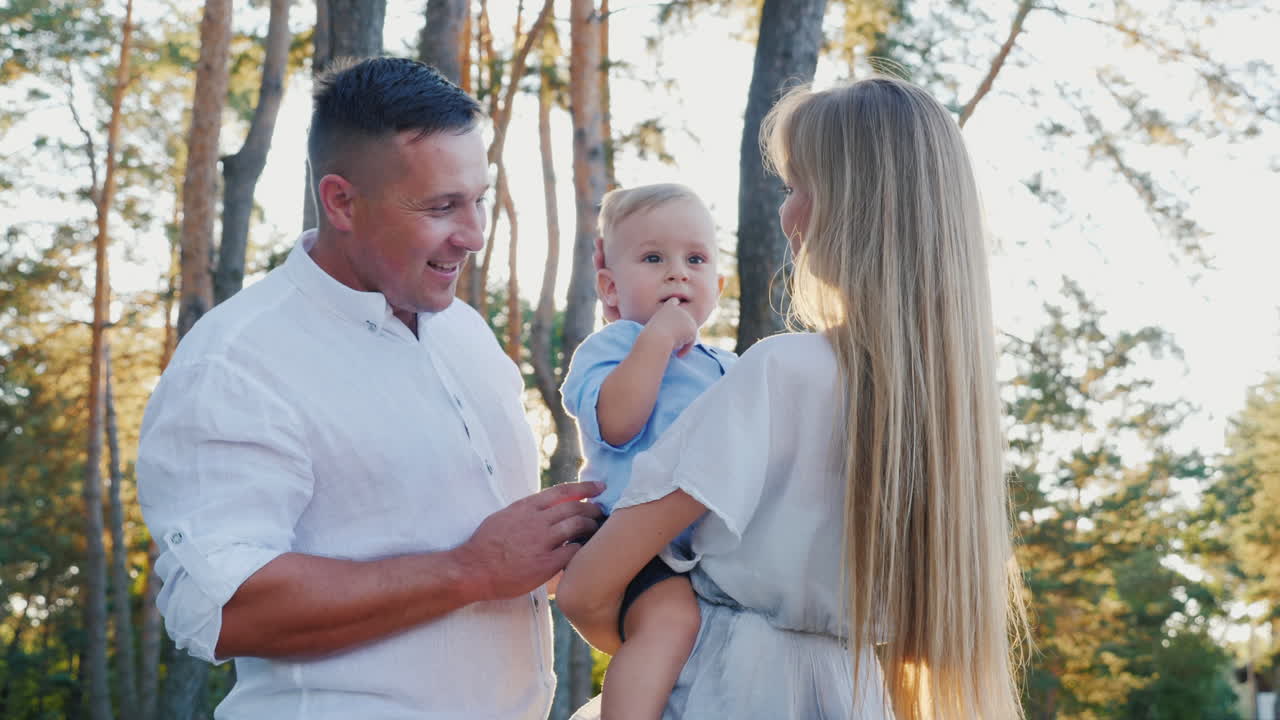 공원 슬로우 모션 비디오에서 걷는 젊은 행복한 가족 엄마 아빠와 아기의 초상화