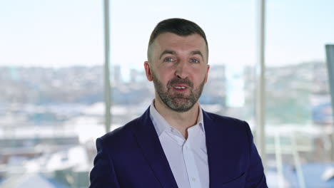 smiling bearded professional businessman looking at camera. confident handsome adult entrepreneur speaking in office. face view business portrait close up.