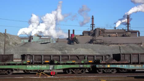 global warming is suggested by shots of a steel mill belching smoke into the air with railcars foreground