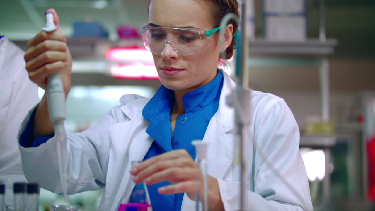 Female chemist doing chemical experiment. Chemical reaction in glass flask