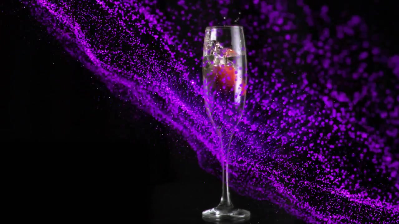 Fragola che scende in un flûte, penetrando nel liquido, con puntini viola effervescenti che si diffondono sul vetro per mostrare il flûte.
