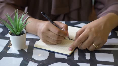 close up of women hand writing on notepad