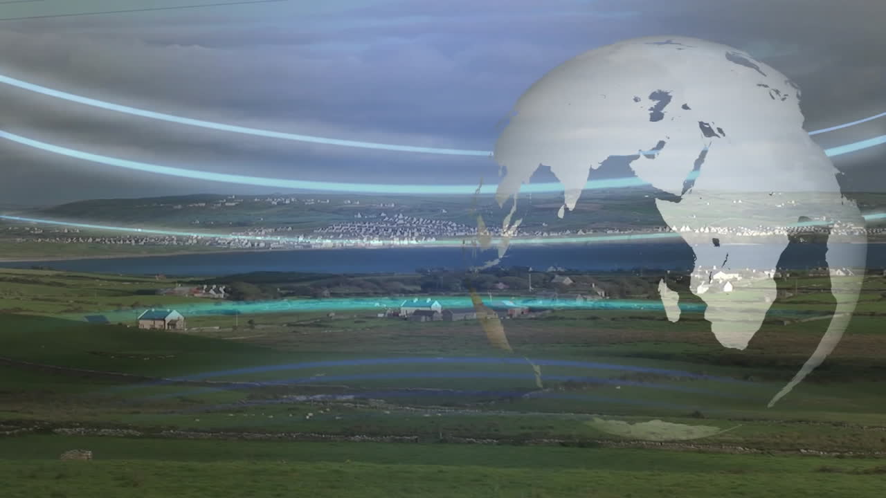 Globe animation over rural landscape with fields and distant town