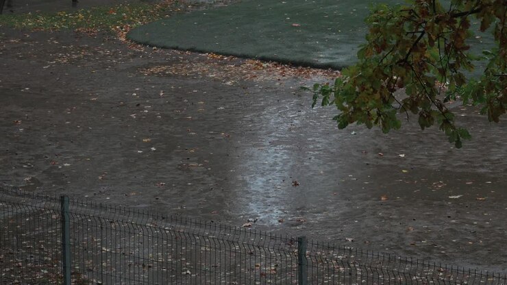 Aerial static shot of empty kids playground while raining
