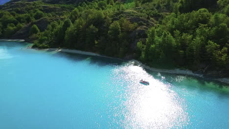 AERIAL---Sunny-reflection,-tour-boat-in-General-Carrera-Lake,-Patagonia,-Chile