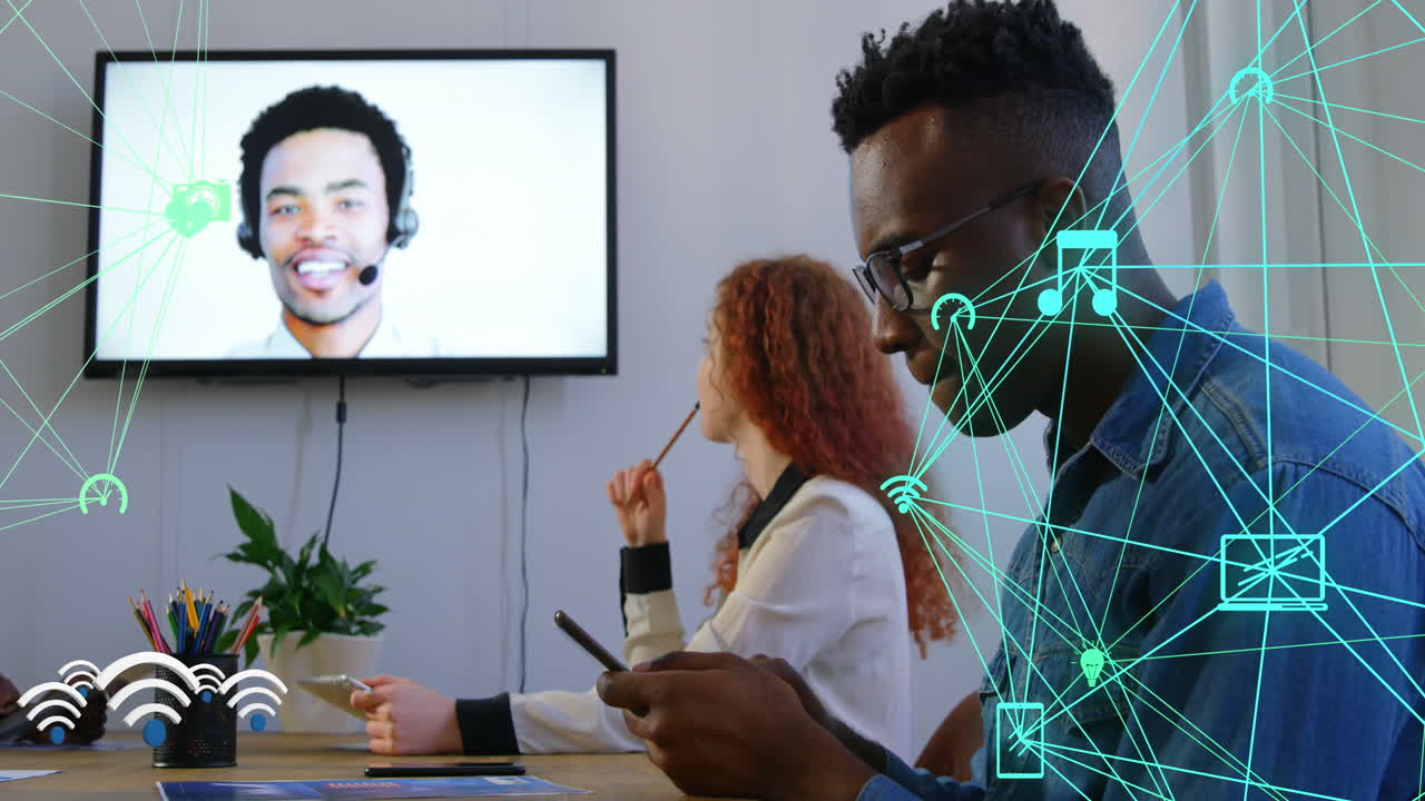 Animation of globes of digital icons over diverse colleagues having a video conference at office