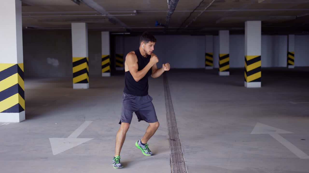 el boxeador hace puñetazos de entrenamiento en el estacionamiento subterráneo