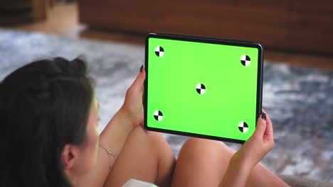 green screen, chroma key of tablet. greenscreen of chromakey mockup and tracking markers. woman watching series on pad