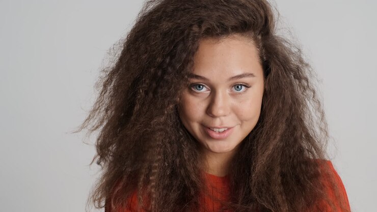 Kaukasische vrouw met krullend haar die lacht.