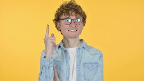 joven pelirrojo pensando en obtener idea, fondo amarillo