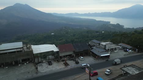 La-Antena-Brumosa-Domina-Los-Edificios-En-Lo-Alto-De-Un-Acantilado-Hasta-El-Distante-Monte-Batur,-Bali.