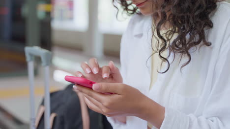 mujer usando el teléfono en la estación de tren