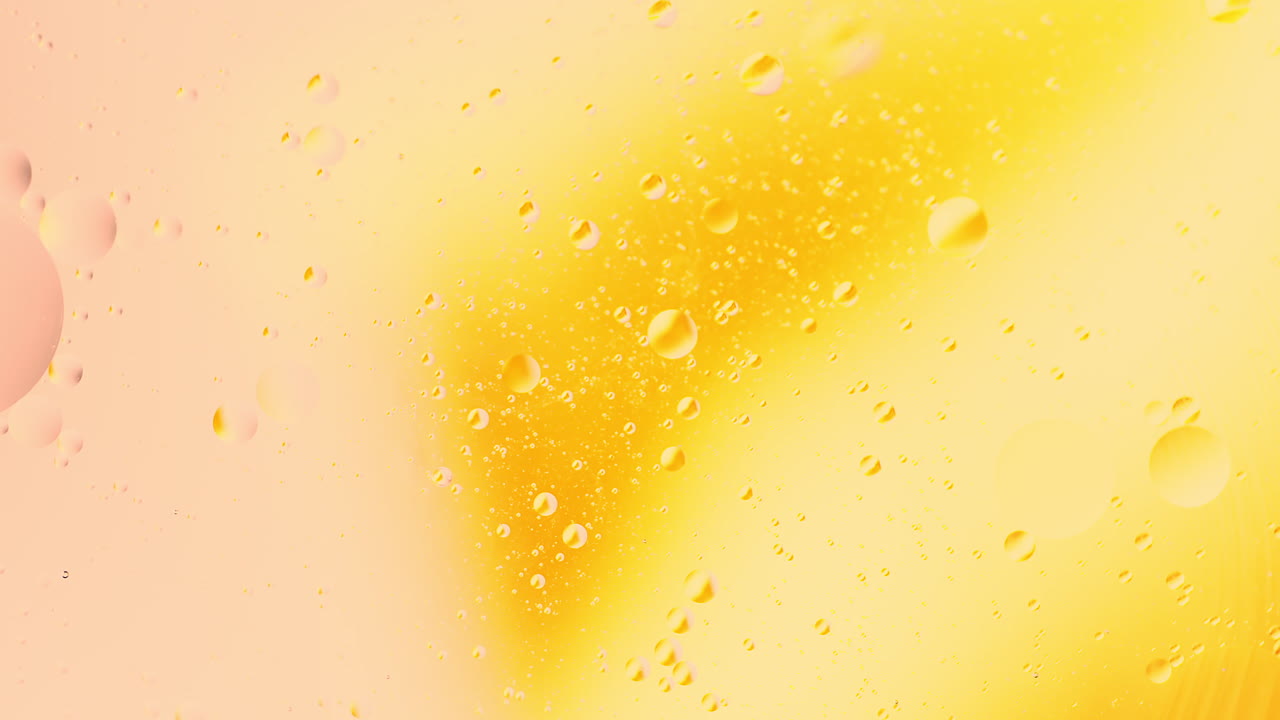 Gocce d'olio astratte e colorate in rotazione nell'acqua con sfondo sfumato di colori che si mescolano