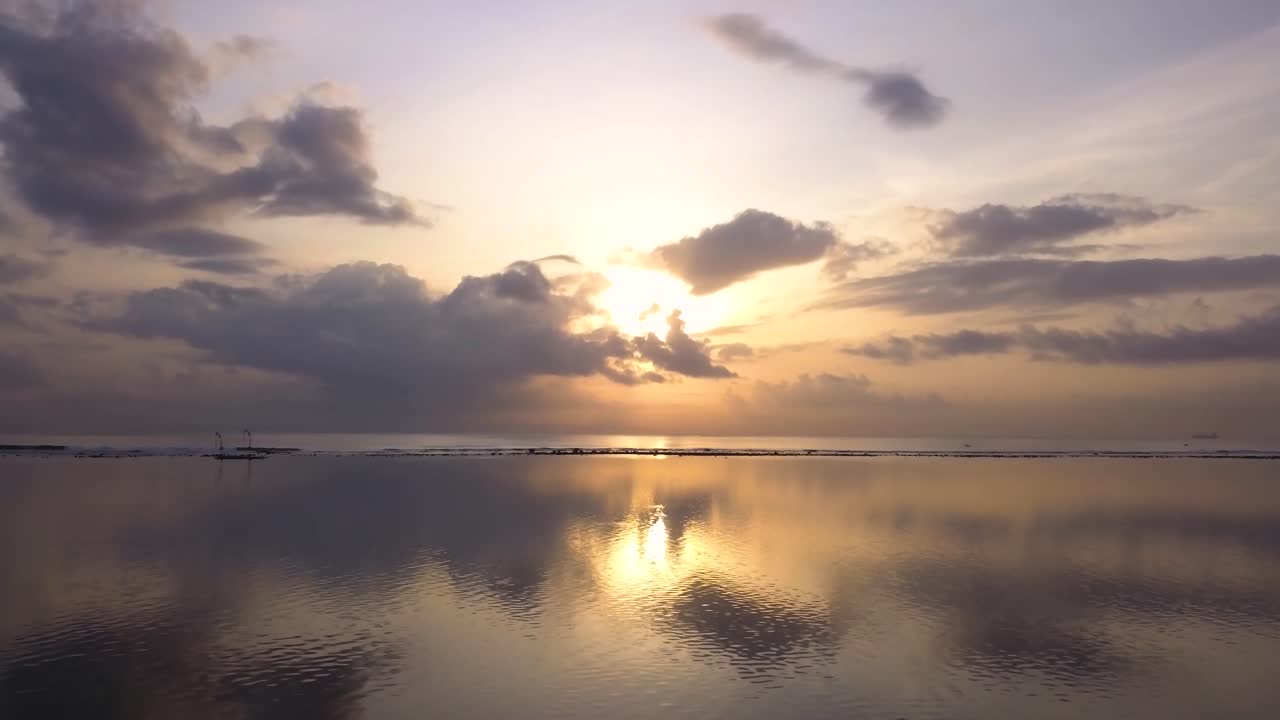 Low angle drone shot of Pantai Karang Beach in Sanur, Bali, Indonesia at sunrise
