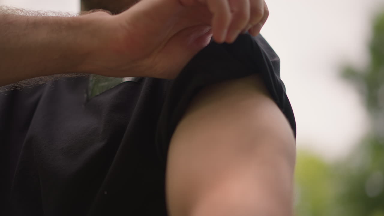 Engaging Muscles Through Deliberate Sleeve Roll, Closing In On Hands And Forearm Movement Details, Man Adjusting His Sleeve With Precision To Ready Arm For Activity In Natural Sunlight