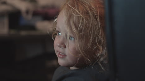 three year old girl watching tv at home