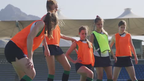 female hockey players exercising on the field