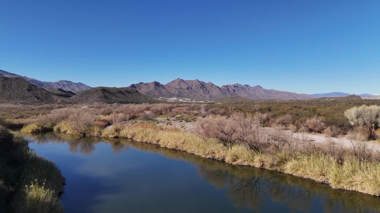 Drone Flying over River. Mountains in the background. Blue Skies. Verde River in Arizona