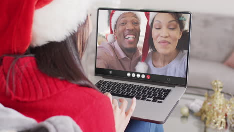 animación de mujer caucásica en sombrero de santa en llamada de video portátil con amigos en navidad