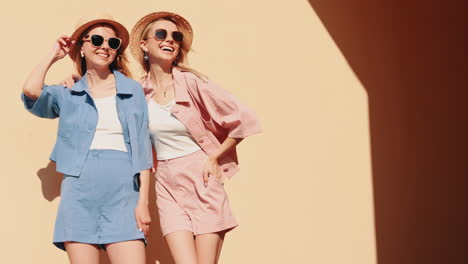 two women in trendy summer outfits