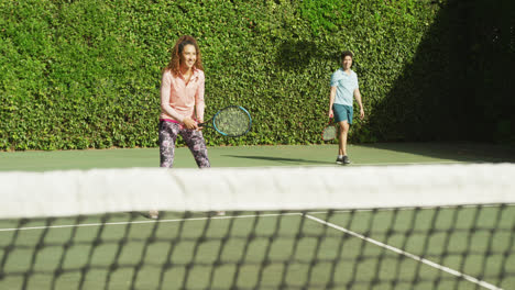 Video-Eines-Glücklichen-Gemischtrassigen-Paares,-Das-Auf-Dem-Platz-Tennis-Spielt