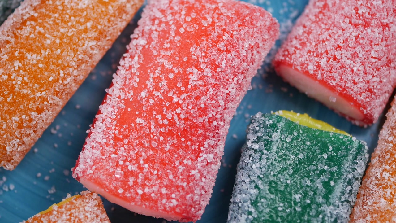 Gomitas de colores cubiertas de azúcar en un plato azul