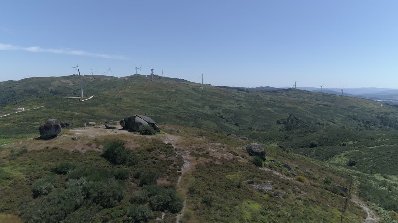 vista aérea de la casa en las montañas con molinos de viento