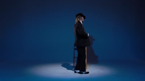 man in suit and fedora posing on stage
