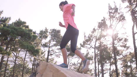 sportswoman raising her hands after climbing rock