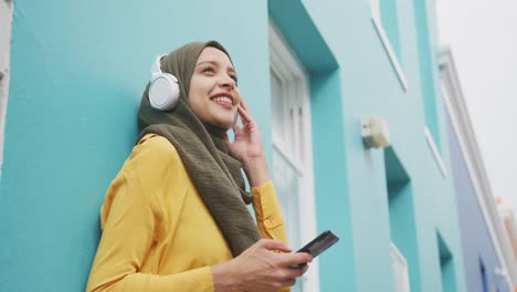 Mujer-Vistiendo-Hijab-Con-Auriculares-Inalámbricos