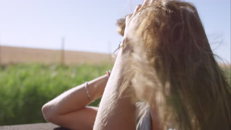 beautiful woman enjoying ride in convertible vintage car on road trip with outstretched arms