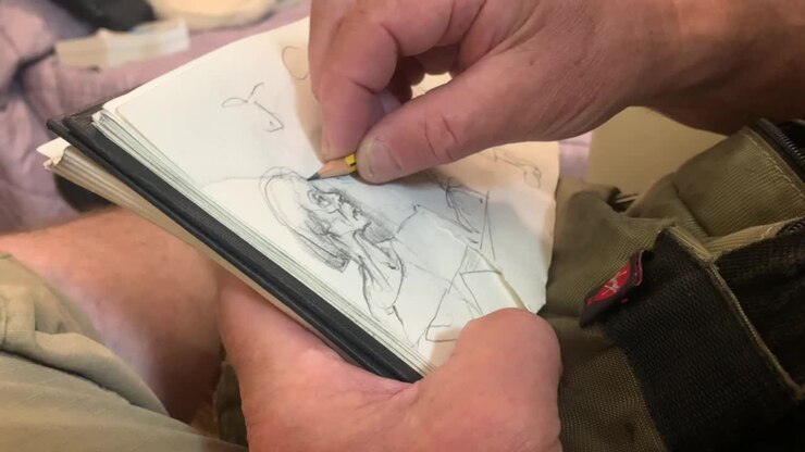 Männlicher Künstler schattiert seine Illustrationen.