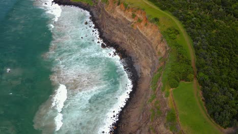 Mountain-trail-and-cliff-overlooking-the-waves--Lennox-Head-Mountain--NSW-Australia--Aerial